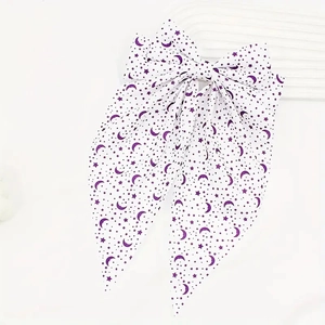 Detail of white bow hair clip with purple crescent star prints and long ribbons