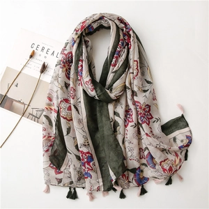 Detail of vintage floral cotton linen shawl featuring red flower patterns and tassel trim