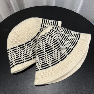Detailed knit texture of a beige fisherman hat with black geometric pattern design