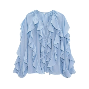 Detailed view of the layered ruffle neck and pleated texture of the light blue blouse