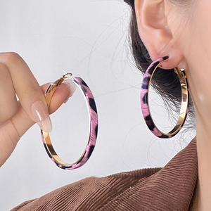 Detail view of large pink leopard print hoop earrings with gold inner metal