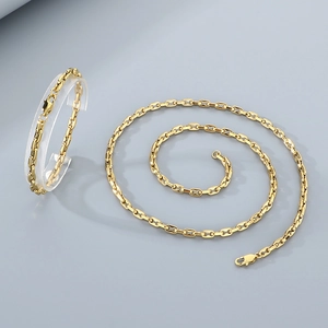 Detailed shot of interlocking 18k gold-plated titanium steel necklace and bracelet set