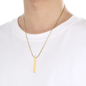 Close-up of minimalist 18K gold plated stainless steel vertical bar pendant on a male model