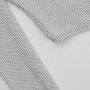 Macro shot of light gray ribbed knit fabric texture on this slim fit bodysuit