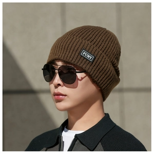 Detail view of brown ribbed knit beanie with brand label and thick warm winter texture