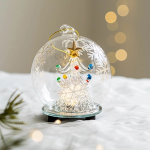 Lighted glass angel Christmas tree ornament with colorful beads and warm glowing bokeh lights