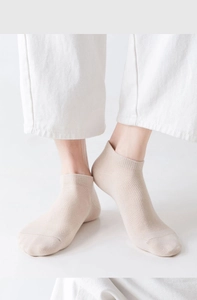 Détail de chaussettes basses en mesh beige respirant portées par un mannequin en lumière douce