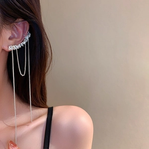 Gros plan d'un ear cuff argenté élégant avec longues chaînes à franges sur mannequin