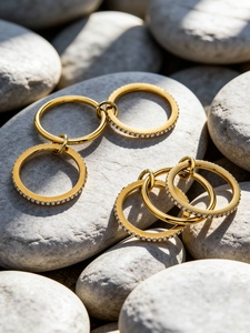Macro detail of gold interlocking rings with micro-paved cubic zirconia on white stones
