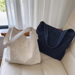 Vista dettagliata delle borse tote in denim e tela con etichetta 'simple wish' su sedia