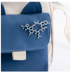 Macro shot of a silver chemical molecule pin on a canvas bag showing metallic texture