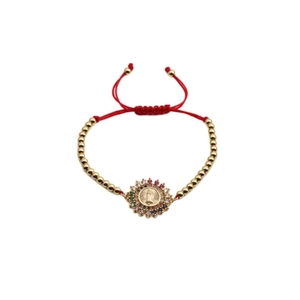 Detailed view of Virgin Mary charm with colorful zircon on red adjustable cord bracelet