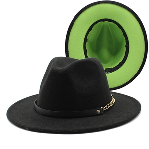 Detail of black wool fedora featuring neon green contrast lining and gold chain band