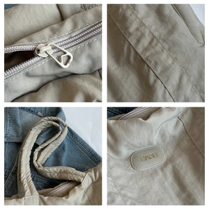 Detail view of smooth nylon tote bag zippers, reinforced stitching and BARE logo