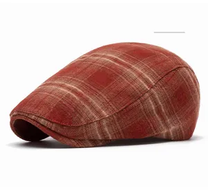 Detail view of red plaid flat cap showing retro check pattern and woolen texture