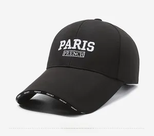 Detailed close-up of a black baseball cap featuring white Paris French embroidery