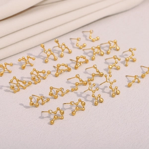 Detailed macro view of 18K gold plated stainless steel constellation stud earrings with cubic zirconia