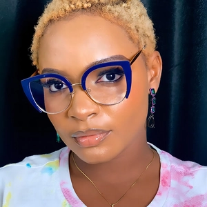 Close-up of blue cat eye glasses frame paired with elegant jewel pendant earrings