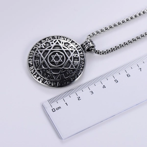 Silver hexagram pendant with zodiac symbols measuring 3.5cm on a scale display