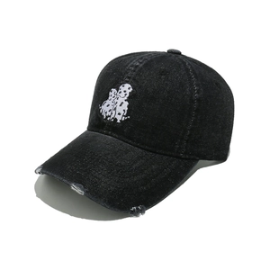 Detail of dalmatian embroidery and distressed brim on washed black denim baseball cap