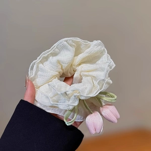 Gros plan d'un chouchou gaufré avec des pendentifs tulipes 3D en blanc et rose