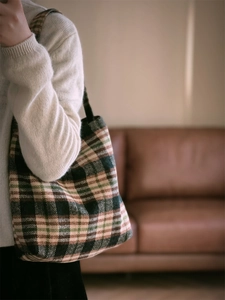 Gros plan d'un sac bandoulière en laine à carreaux vintage vert et beige