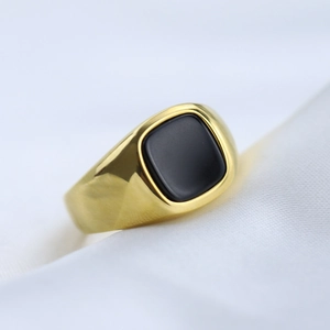 Vintage gold stainless steel signet ring with a black square gemstone on white silk