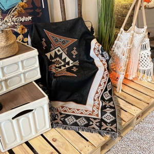 Detail of ethnic geometric pattern woven throw blanket with decorative fringe edges