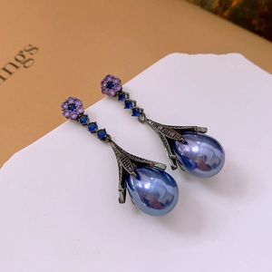 Detailed close-up of vintage flower drop earrings with blue crystal and pearl drops