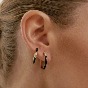Close-up of S925 silver hoop earring with black enamel and sparkling zircon on model