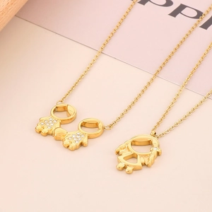 Detail of gold-plated boy and girl pendants with sparkling crystals on dainty chains