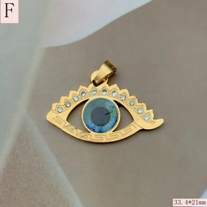 Detail view of golden evil eye heart pendant with Greek key pattern and cubic zirconia