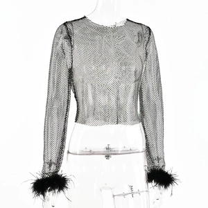 Vue détaillée du crop top noir en résille avec poignets en plumes et manches longues