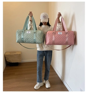 Sacs de voyage matelassés rose et vert menthe portés par un mannequin dans un salon