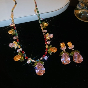 Close-up of luxury gold jewelry set with colorful zircon stones and pear-shaped pink gems