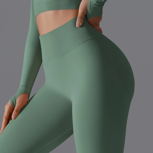 Detail of high-waist seamless yoga leggings and thumb-hole top in sage green color