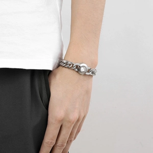 Close-up of polished silver cuban chain bracelet with crystal skull clasp on wrist