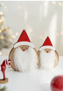 Detailed view of two wooden Santa Claus figurines with soft beards on a warm bokeh background