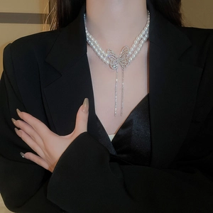 Elegant double-layered pearl necklace with a sparkling diamond butterfly tassel pendant