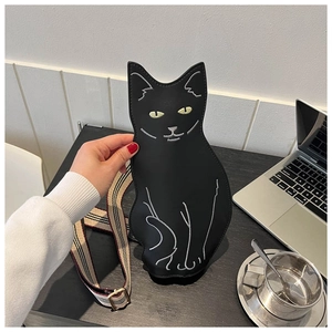 Detail of cute black cat crossbody bag with white embroidery and striped fabric strap