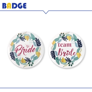 Detail of Bride and Team Bride floral wedding badges with elegant pink script text