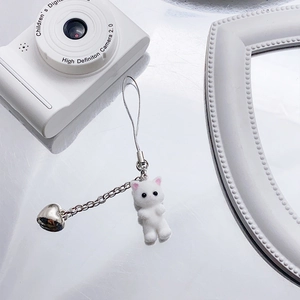 Close-up of white flocked cat keychain with silver metal chain and heart-shaped bell
