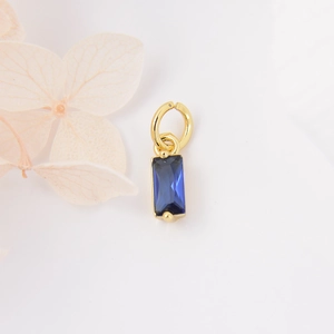 Macro-opname van rechthoekige blauwe zirkoon hanger met gouden rand voor DIY sieraden