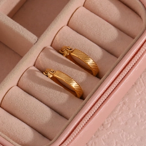 Macro shot of 20mm gold-plated hoop earrings with diagonal texture in a jewelry box