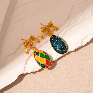 Detail of vintage enamel bow earrings with colorful geometric patterns and gold finish