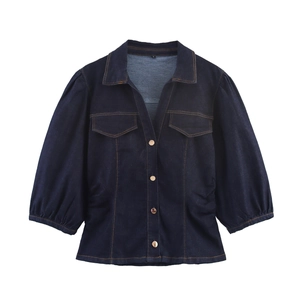 Camicia di jeans blu scuro con maniche a sbuffo e bottoni dorati su sfondo bianco