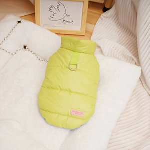 Detail of green quilted pet vest with metal D-ring for leash and pink brand label