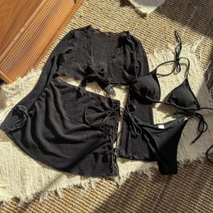 Dettaglio del set bikini nero 4 pezzi all'uncinetto con copricostume e gonna coordinata