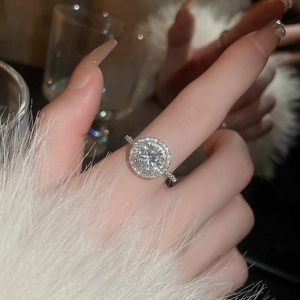 Close-up of sparkling halo zircon ring on finger with micro-pave silver band