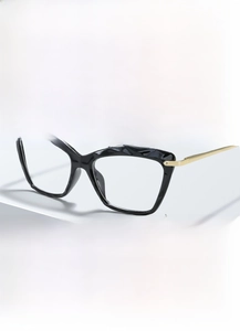 Detail of black cat-eye frames with faceted texture and gold metal temples on a white stand